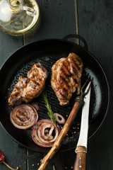 Grilled steak of pork with spices, rosemary and chili pepper in a frying pan