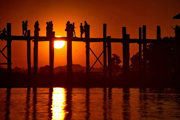 Mandalay. Myanmar. 11/22/2016. The bridge across the lake Taungthaman. Every night dozens of tourists from all over the world, standing on the famous U Bein bridge, watching the beauty of the sunsets 