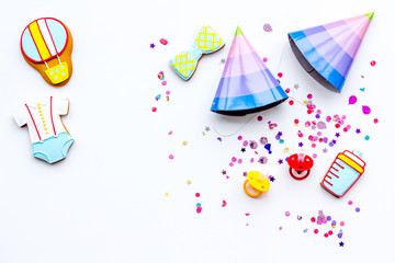 Obraz premium Baby shower. Cookies in shape of accesssories for child and party hats on white background top view copy space