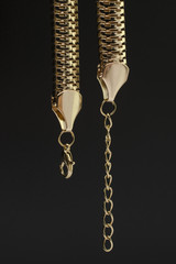 Golden chain detail clasp isolated on black