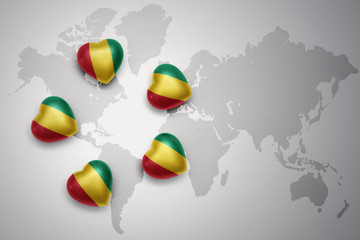 five hearts with national flag of guinea on a world map background