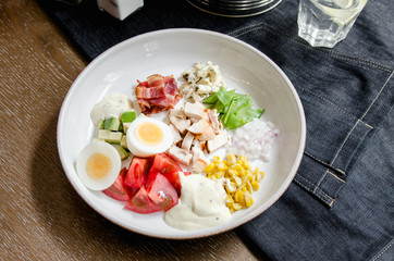 Healthy Hearty Cobb Salad with Chicken, Bacon, Tomato, Onions, Eggs, green beans. American food. Close up, home made