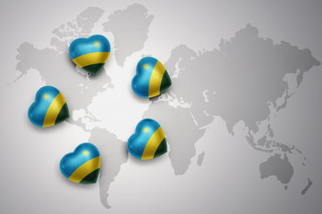 five hearts with national flag of rwanda on a world map background