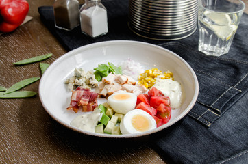 Healthy Hearty Cobb Salad with Chicken, Bacon, Tomato, Onions, Eggs, green beans. American food. Close up, home made