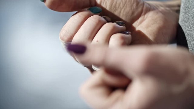Closeup shot of woman with rough female hands with taped fingers clenching fists after weightlifting