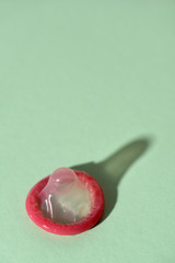 rolled-up condom on a green background