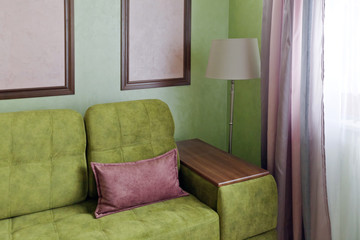 Фрагмент интерьера с диваном в розовых и зеленых цветах