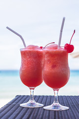 Two tropical coctails on a wattled table against the turquoise sea, Redang island, Malaysia