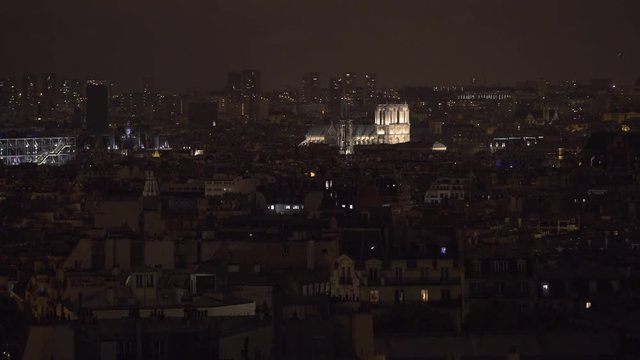 PARIS, FRANCE  – SEPTEMBER 2016 : Video shot of central Paris rooftops at night with view of Notre Dame