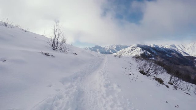Forward POV hiking and walking with snowshoes outdoor on white snowy path in mountain wild field in winter. Trail on snow.Point of view 4k video             