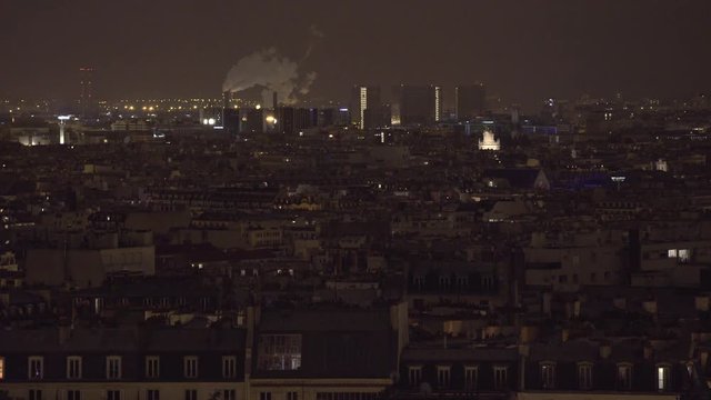 PARIS, FRANCE  – SEPTEMBER 2016 : Video shot of central Paris rooftops at night with view of cityscape and factory smoke