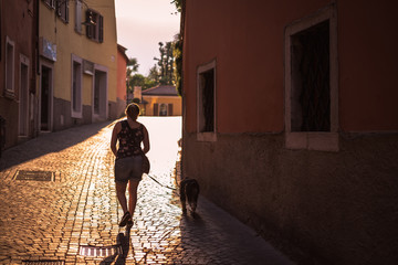 The girl is walking her dog on the street