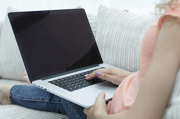 young woman working with laptop sitting on sofa