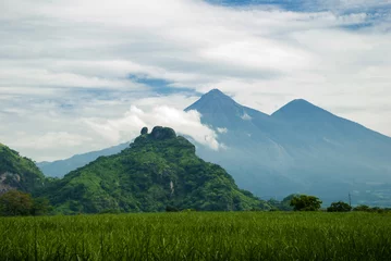 Foto op Canvas The mountains and volcano of Fuego rural scenery in summer. Guatemala, sugar cane. © Byron Ortiz