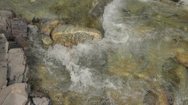 Beautiful water in a mountain river in slow motion video. Shooting speed 180fps, slow motion. Live shooting of the most beautiful nature river mountain water. The camera is static.