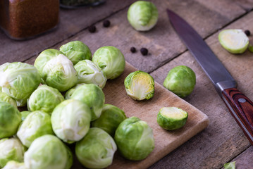 Brussels sprouts on wooden cutting desk on rustic table.