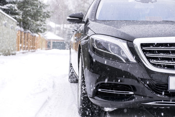 Fototapeta premium Car on Snowy road in snowfall
