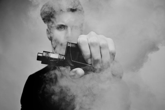 Vaping man and a cloud of vapor