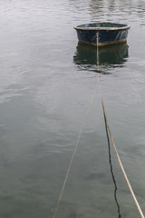 small boat moored with a rope in calm water