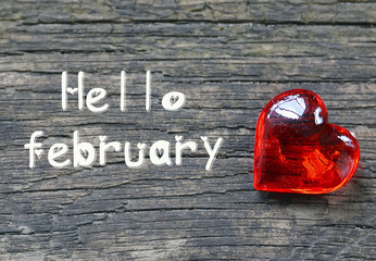 Hello February.Decorative red heart on rustic wooden background.Winter holidays or Valentines Day concept.Selective focus.