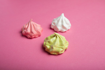 Children's small spiral meringues on a pink background - an expression of love for Valentine's Day.