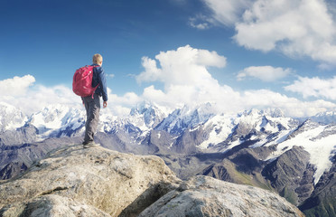 Fototapeta premium Tourist on the mountain range in the clouds. Active life concept
