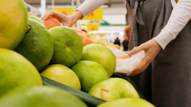 Girl picks fruit in a vegetable shop close-up, 4k.