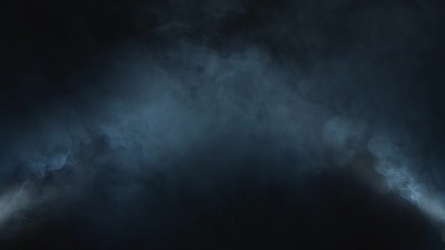 Dense smoke illuminated from two sides swirls on black background