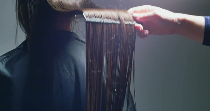 Woman stylist combing hair. Hair preparing