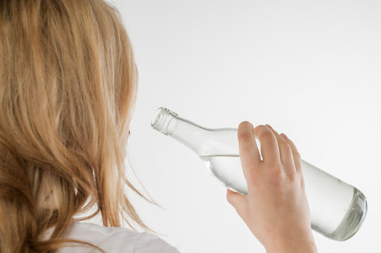 Girl drinking from glass bottles.