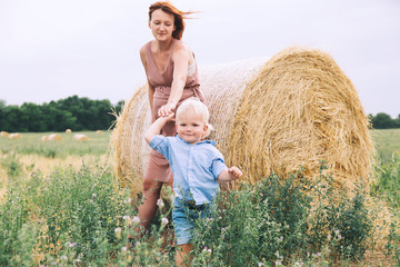 Pregnant woman and son on nature. Mother waiting of a second baby.