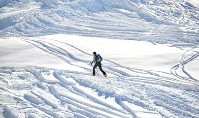 Fototapeta na wymiar Skier climb on skis and sealskins.The ski slope and skiers at Passo Groste ski area ,italy