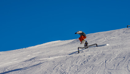 MADONNA DI CAMPIGLIO, ITALY-21 November 2014:Snowboarder jumping through air with deep blue sky in background in Madonna di Campiglio mountain ski resort