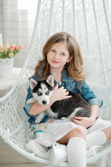 Cute little girl hugging a husky puppy on a white background. Symbol of new year 2018