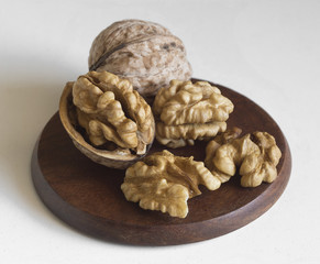 close-up walnuts and shells on wood plate