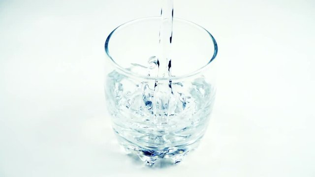 Water is poured in a glass. Slow motion. 240 fps.