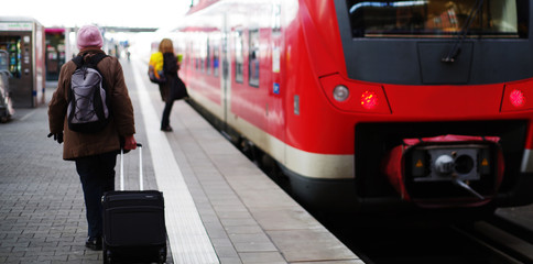 Fototapeta premium Zugfahrt, Passagiere auf dem Bahnsteig 