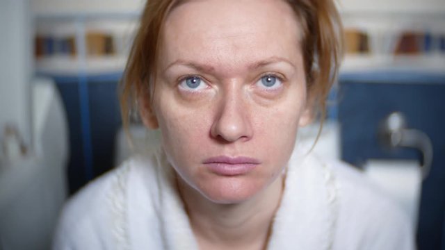 portrait. pale woman is sitting in the toilet on the toilet. 4k, blurred background.
