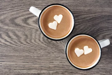 Crédence de cuisine en verre imprimé Chocolat Deux tasses de chocolat chaud avec des guimauves en forme de coeur sur un fond en bois