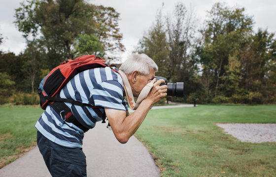 Side View Of Senior Man Photographing With Camera