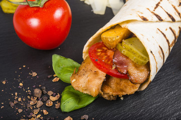 Burrito with slices of roast meat, pickles and fries