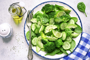 Detox spring salad from green vegetables (avocado, cucumber, broccoli and baby spinach).Top view.