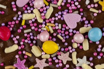 Obraz na płótnie Canvas Close up of a chocolate biscuit sprinkled with colourful candy t