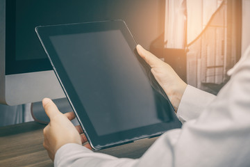Close up hands holding tablet of business woman using on her working desk