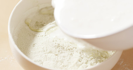 Fototapeta na wymiar Adding water to the flour
