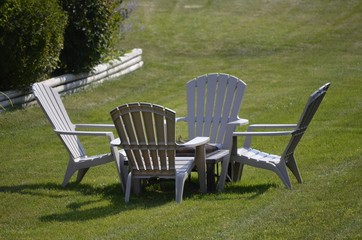 Four chairs gathered around a fire pit in the backyard for social time with friends and neighbors