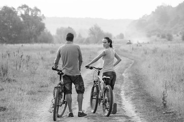 Young couple on bicycles in the field.Black and white.