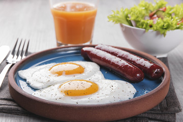 fried chicken eggs with sausages breakfast on a plate with salad