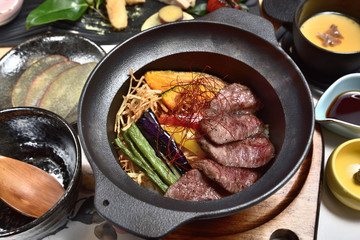 Japanese food - Sliced beef steak with fried vegetables cover rice 