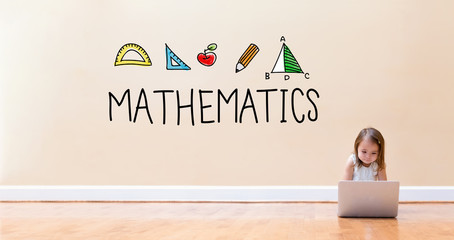 Mathematics text with little girl using a laptop computer on floor